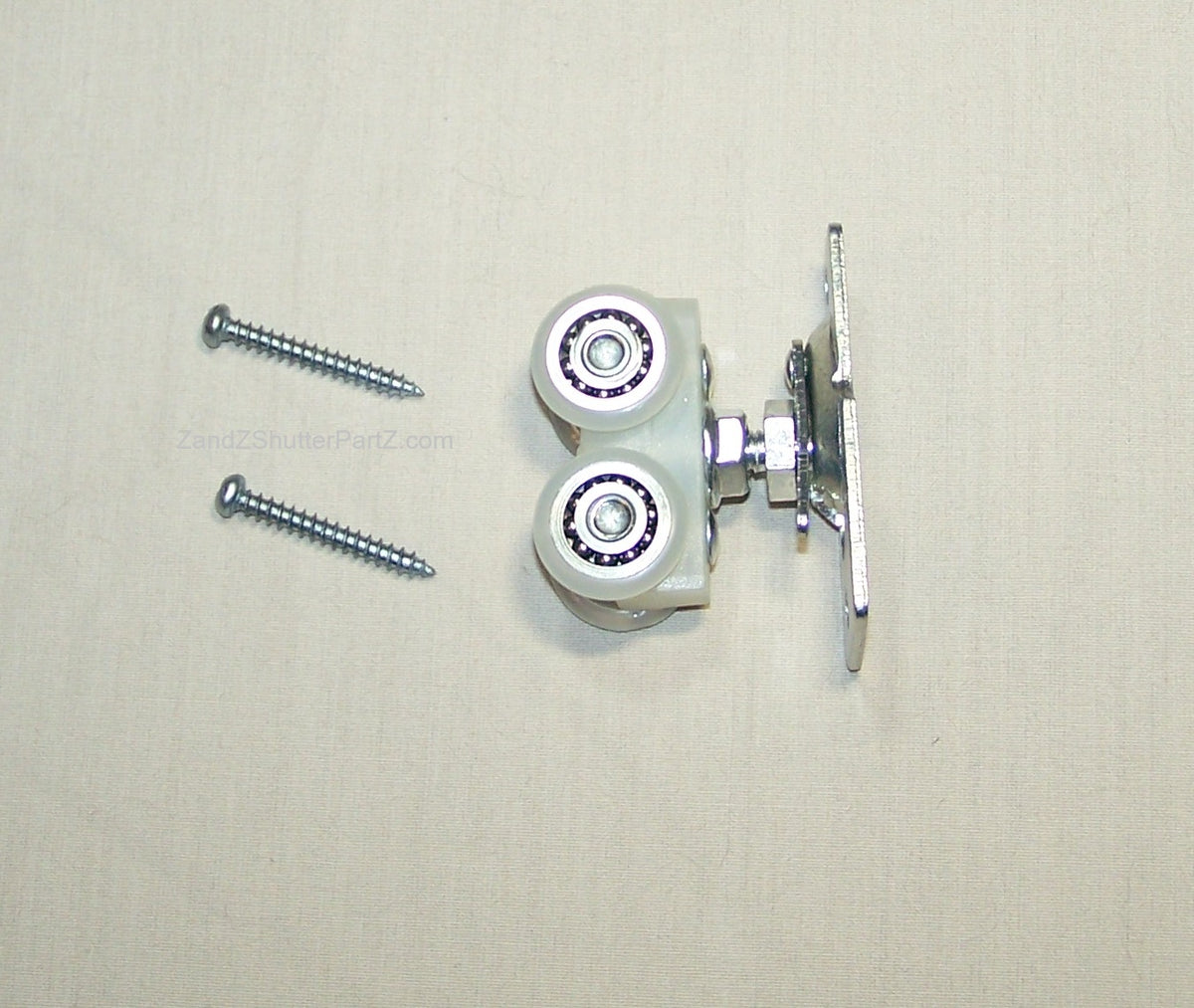 A metal roller assembly with two white rollers, silver bearings, and a mounting bracket, shown with two silver screws on a light beige textured background.